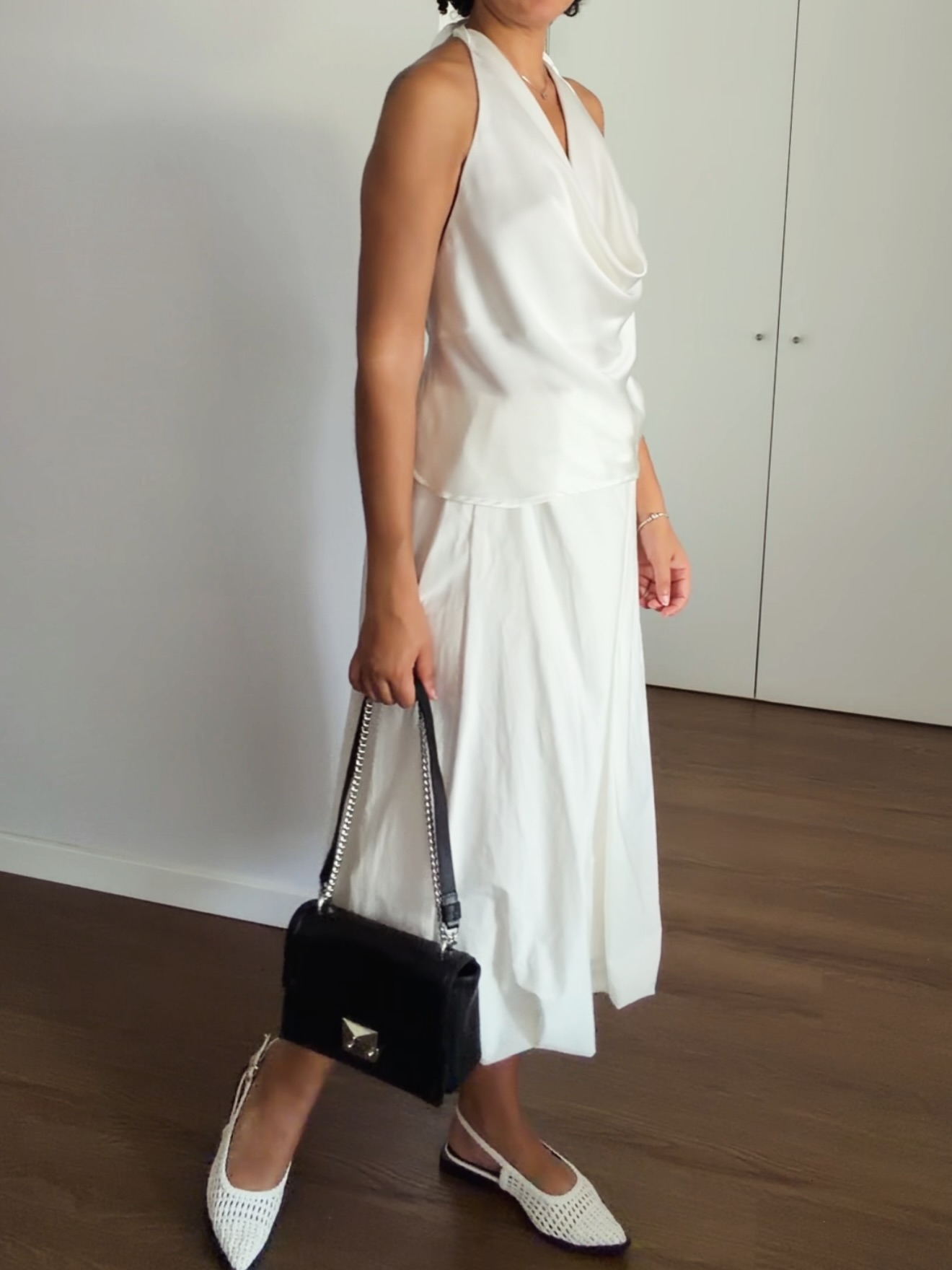 Look final com vestido branco, bolsa preta e sapatilhas claras